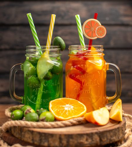 vertical-view-delicious-fresh-juices-fruits-wooden-tray-brown-background
